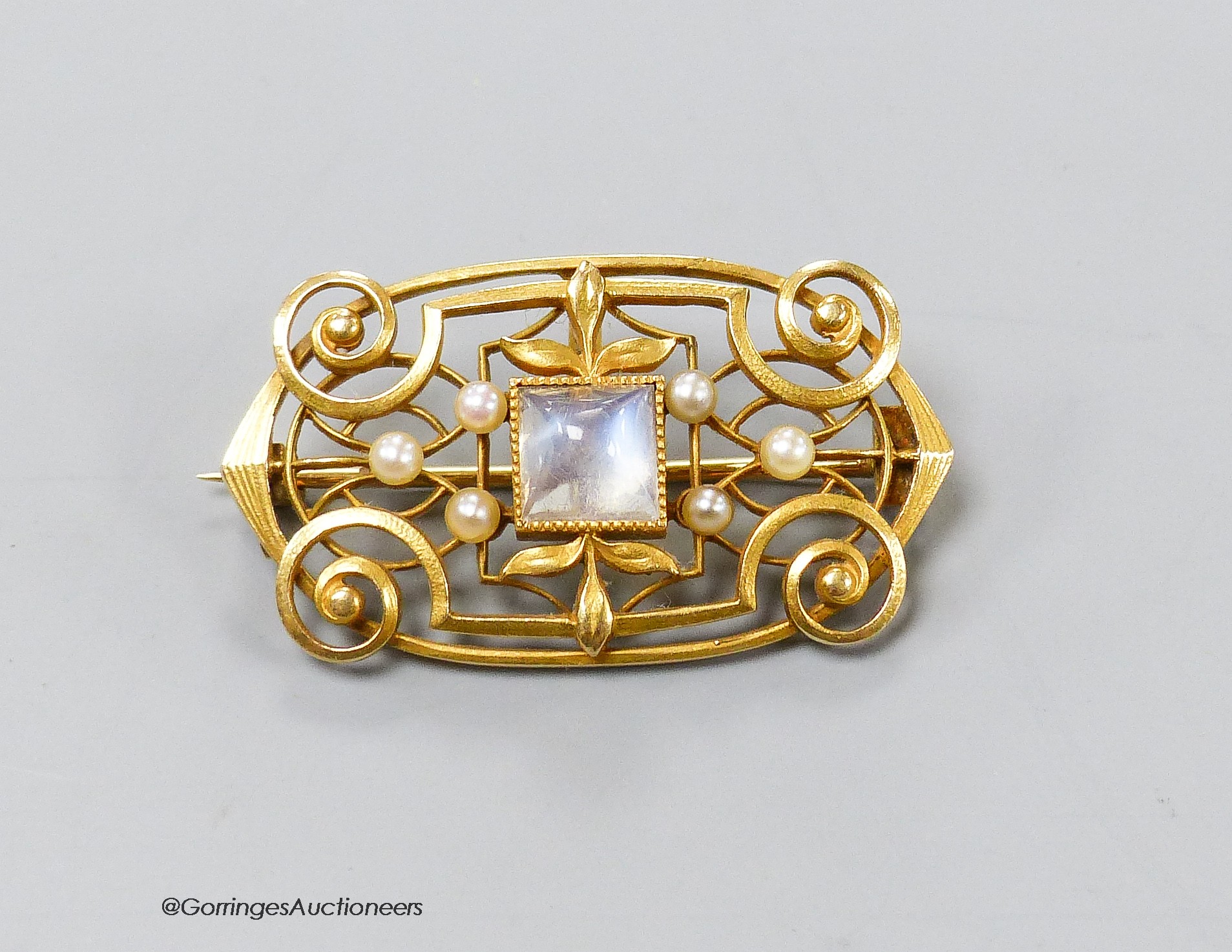 A 14k yellow metal openwork pendant brooch set with square-cut cabochon moonstone and six seed pearls, 32mm, gross weight 5.6 grams.